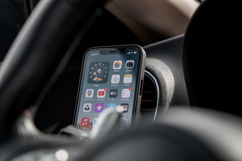 black iphone 4 on black steering wheel