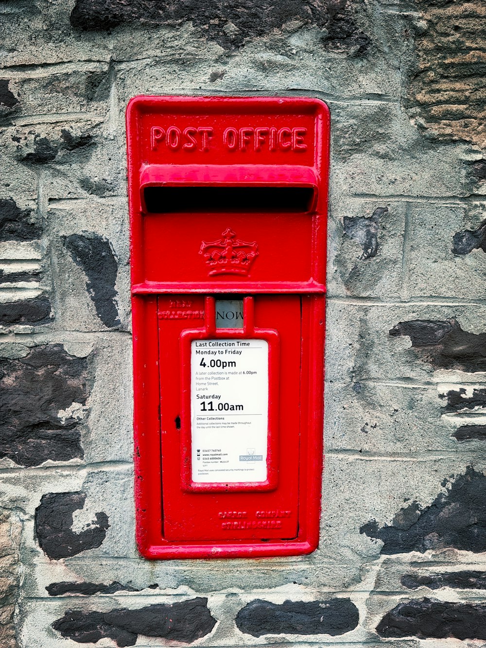 Buzón de correo rojo sobre pared de hormigón gris