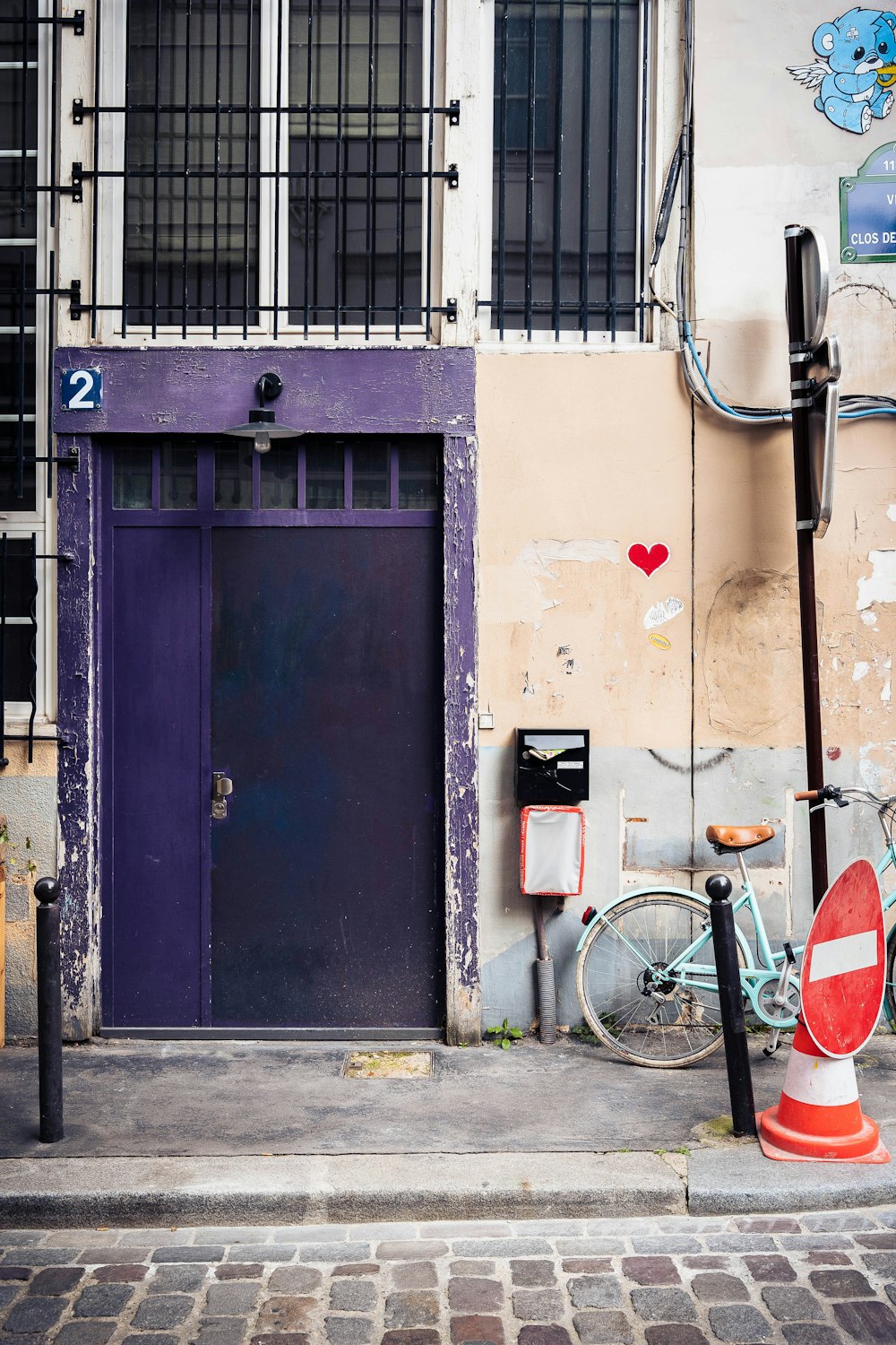 blue wooden door beside red and white road bike