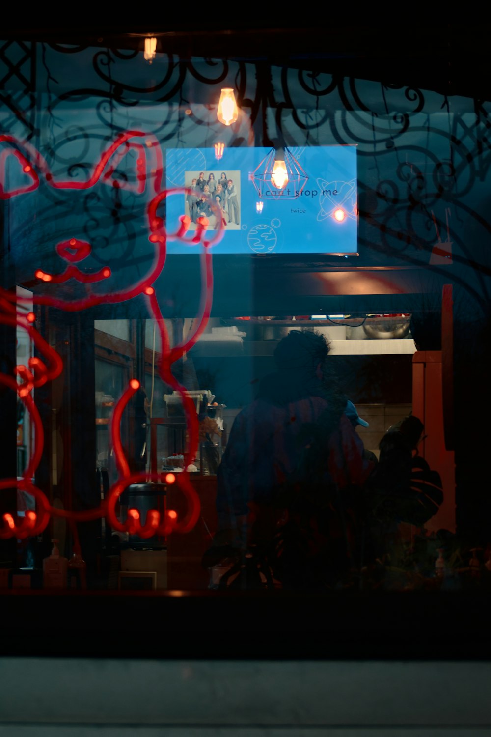 man in black jacket standing near red and white neon light signage