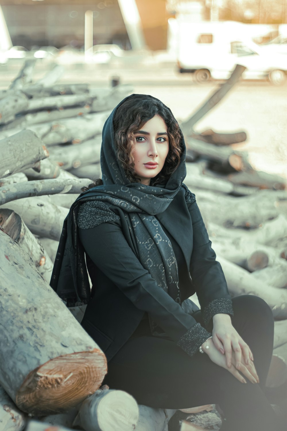 donna in hijab nero seduta sulla roccia durante il giorno