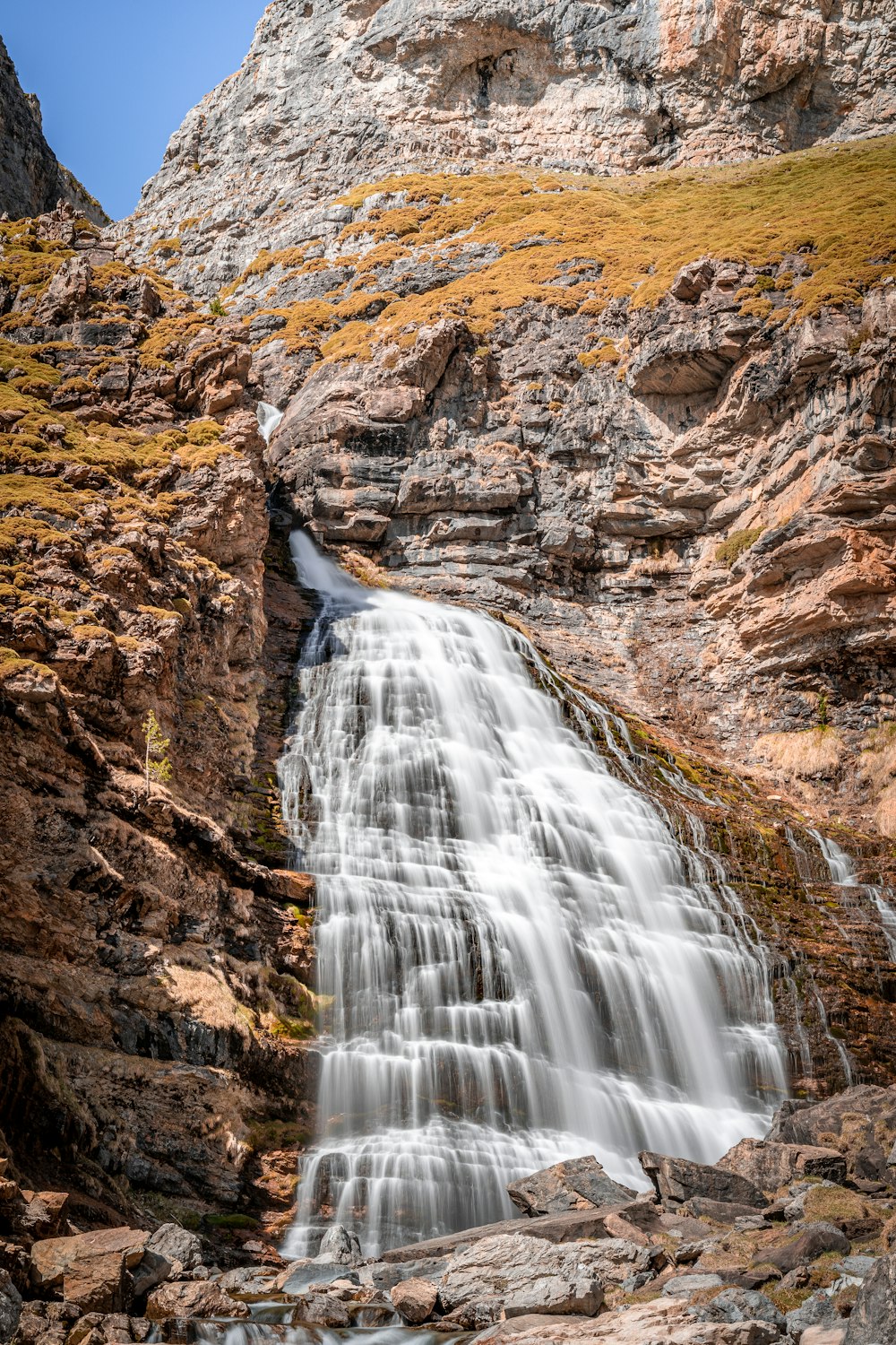 water falls on brown rocky mountain