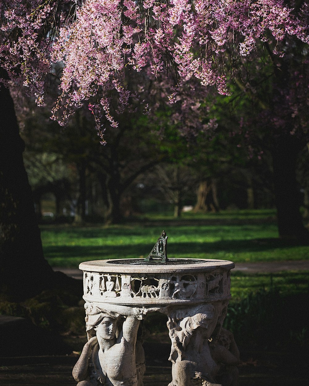 grey concrete fountain with pink leaves