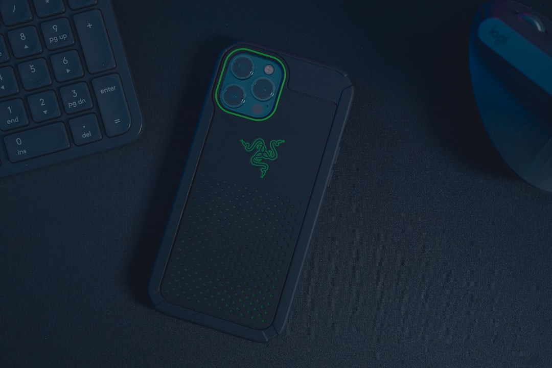 black and green iphone case, iPhone 12 Pro Max with Razer case on a black table