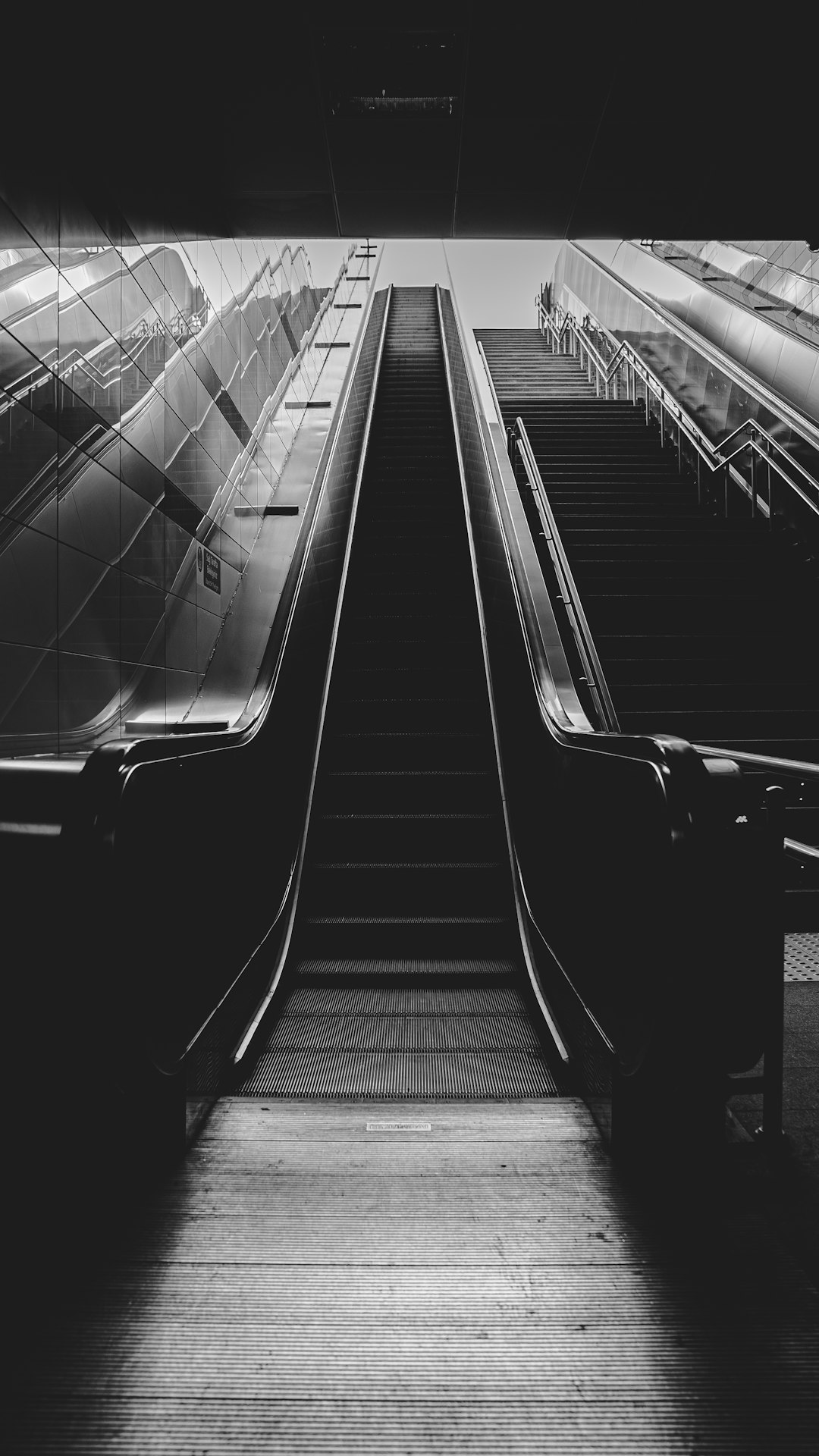 black and white photo of escalator