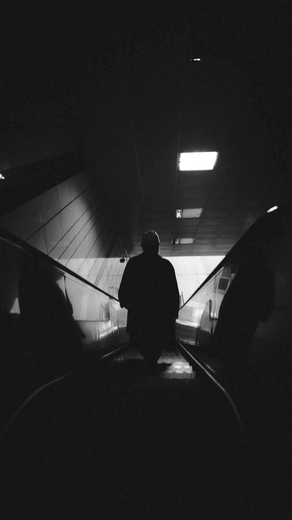 silhouette of man walking on tunnel