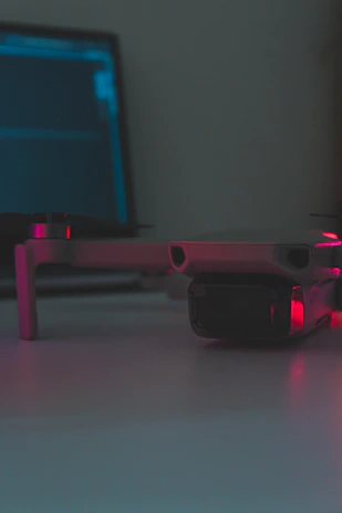 A technician inspecting drone battery connections under bright workshop lighting.