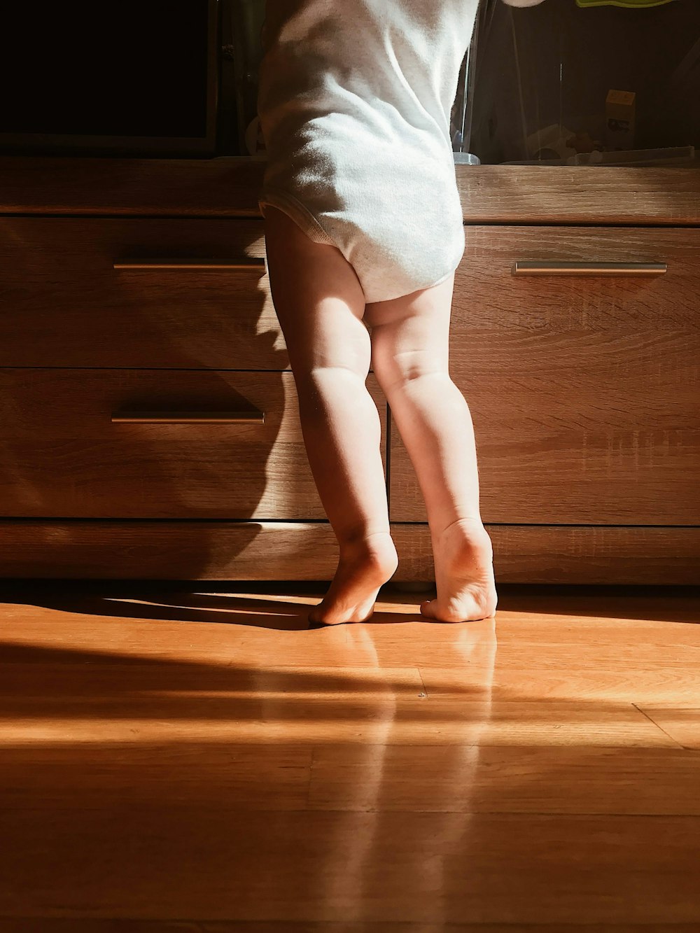 woman in white skirt standing on brown wooden floor