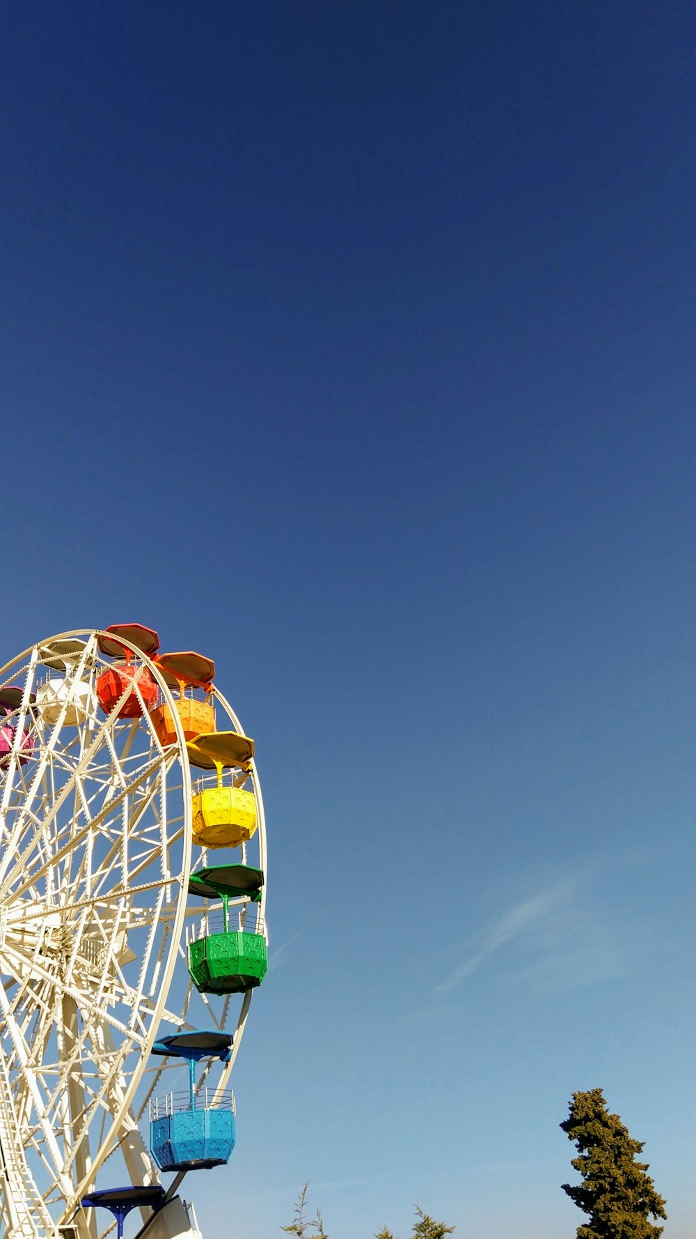 white green and orange ferris wheel under blue sky during daytime