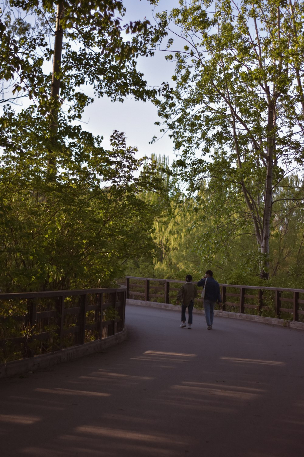 2 men walking on sidewalk during daytime