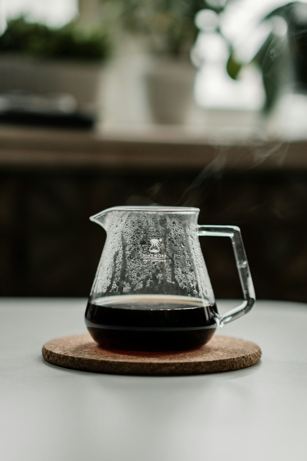 clear glass pitcher on brown wooden table