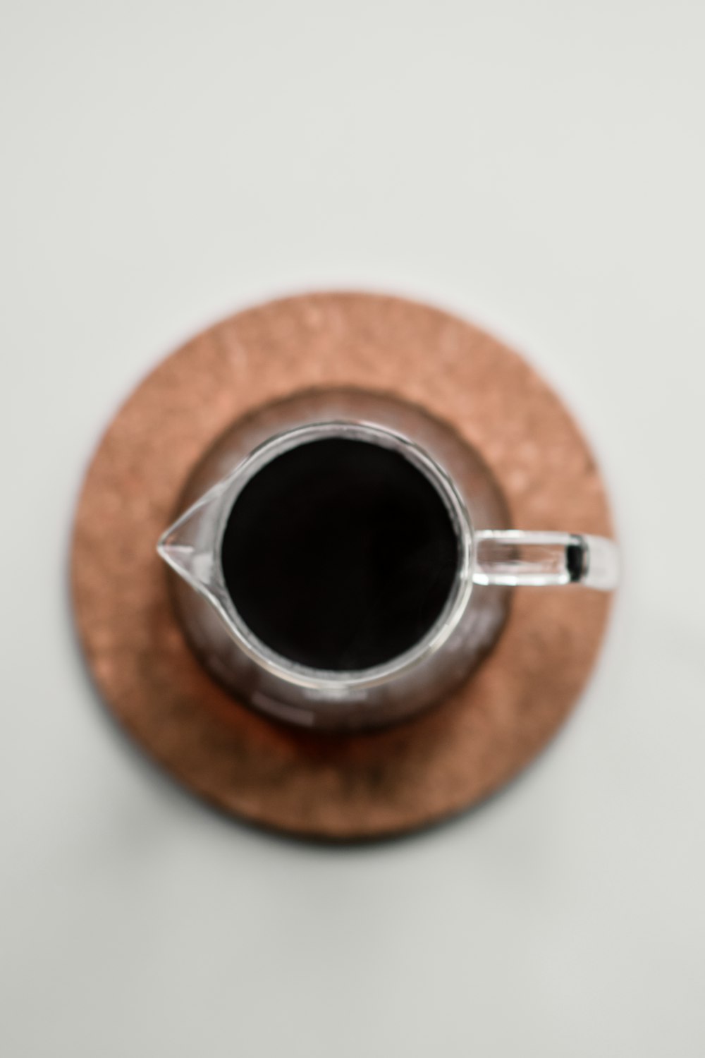 black coffee in brown ceramic mug on brown wooden round table