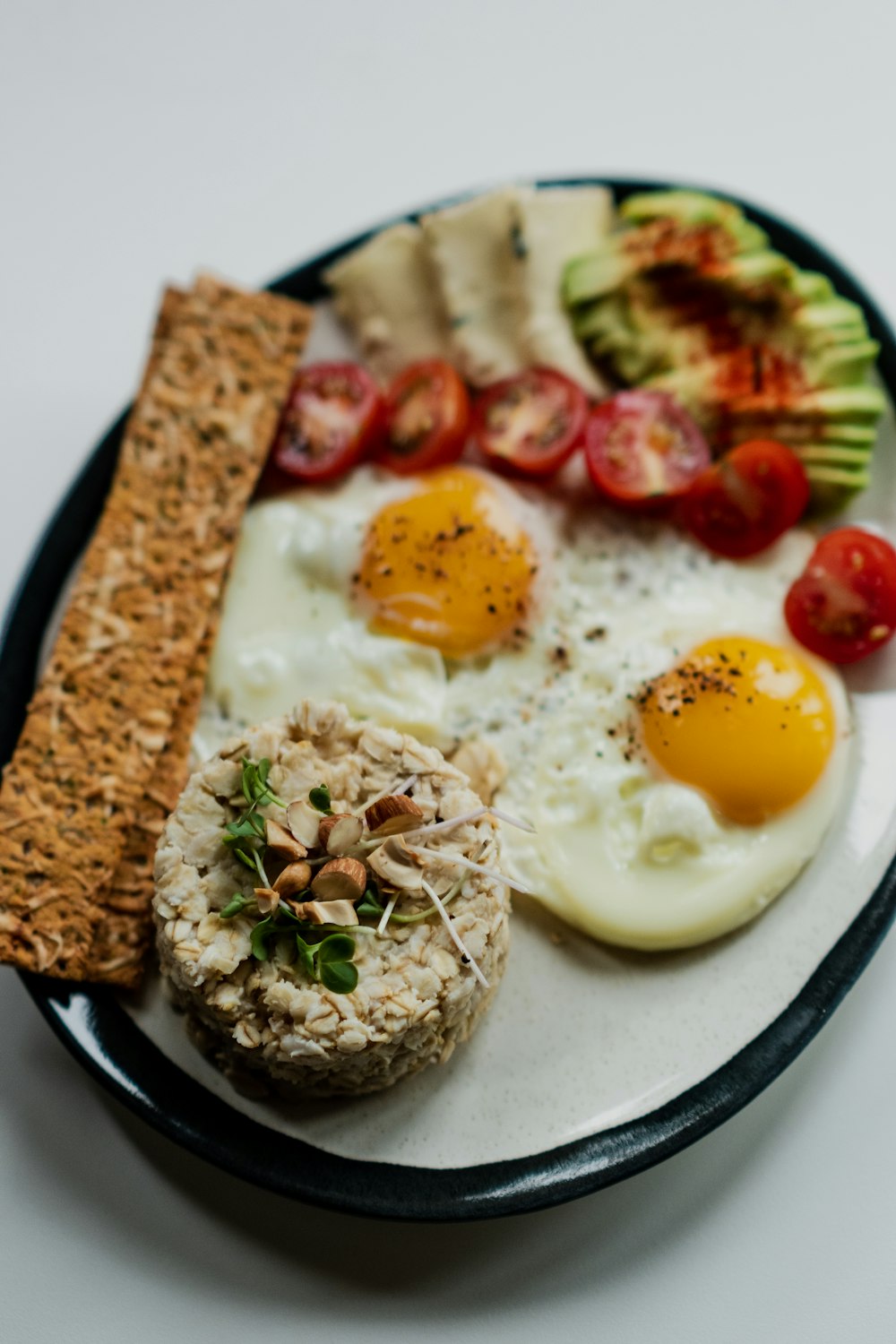 egg with sliced tomato and green vegetable on white ceramic plate