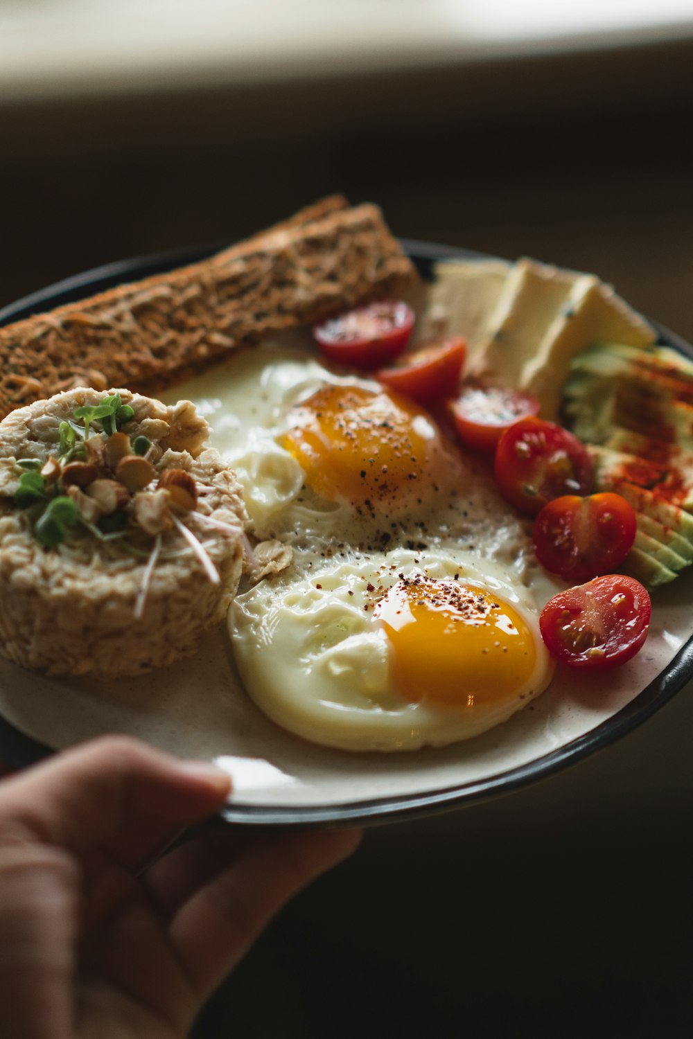 egg with sliced tomato and green vegetable on white ceramic plate