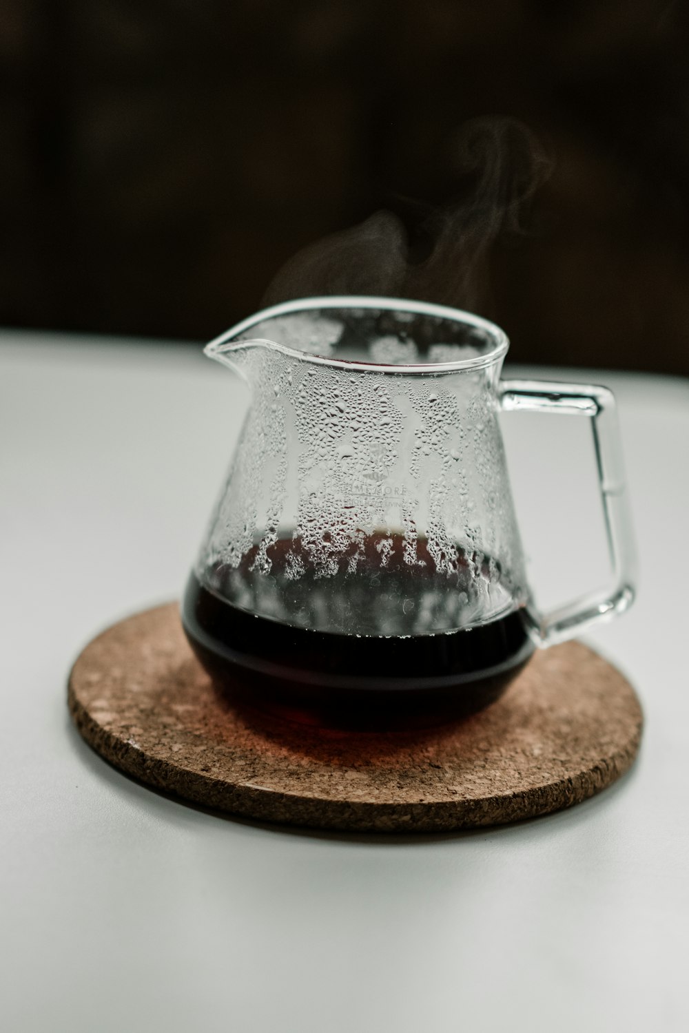 clear glass pitcher on brown wooden coaster