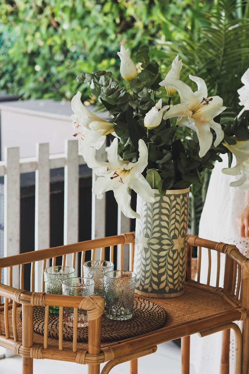 white flowers in white and blue ceramic vase on table