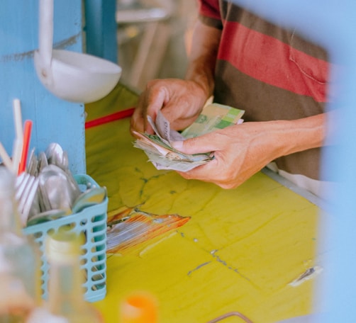 person in green shirt holding white plastic pack