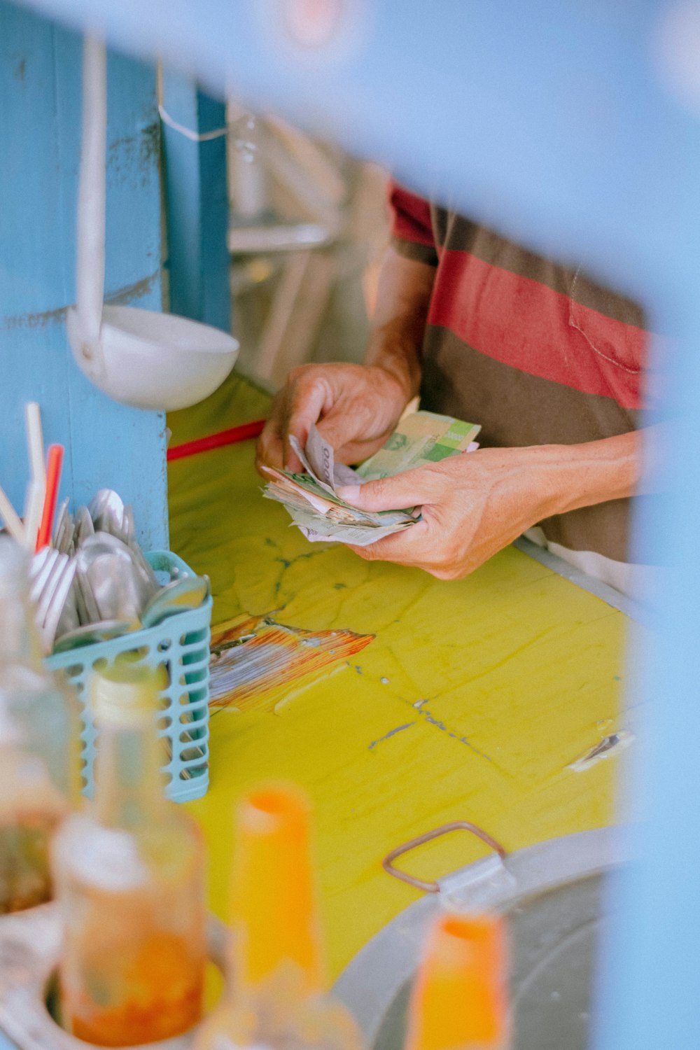 person in green shirt holding white plastic pack