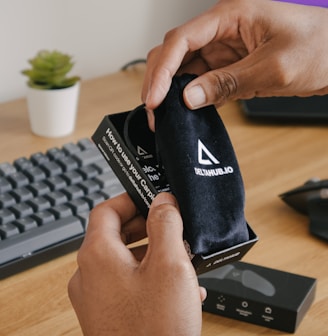 person holding black and white adidas pouch