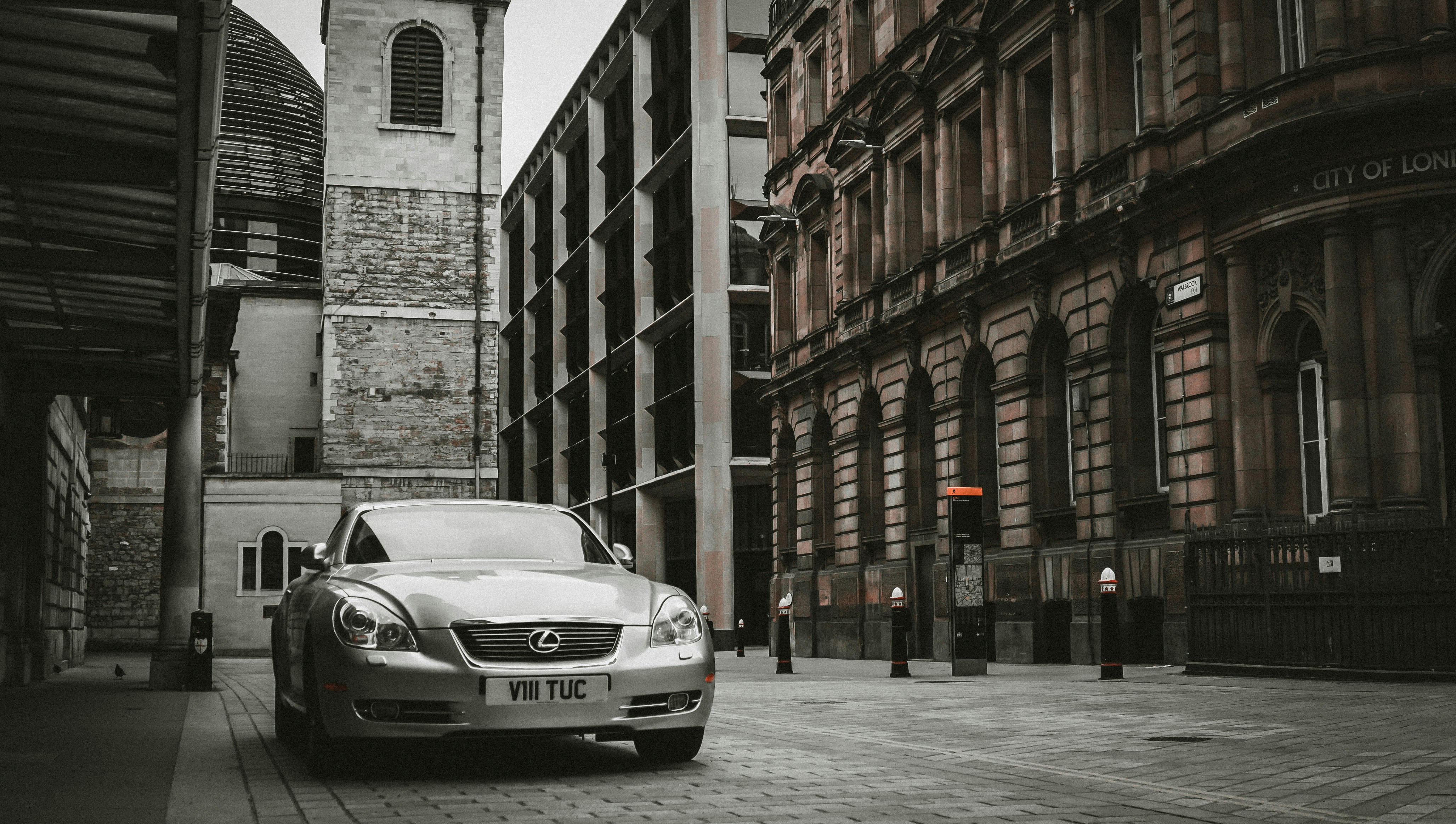 silver mercedes benz coupe parked beside building during daytime