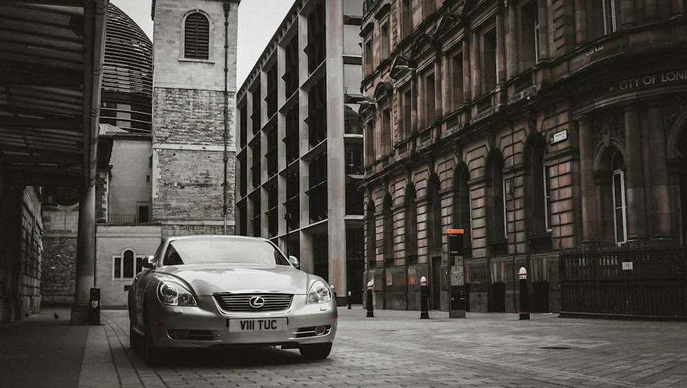 silver mercedes benz coupe parked beside building during daytime