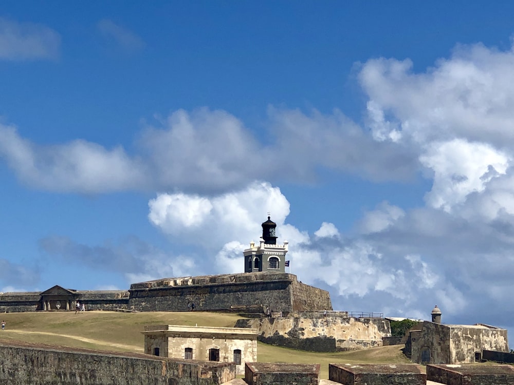 Bâtiment en béton blanc sous le ciel bleu et les nuages blancs pendant la journée