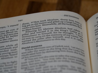 A close-up image of an open book displaying text from the Old Testament. The page is mostly filled with text, including a verse number, and a distinct title. The print is clear, emphasizing the religious context.