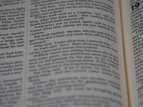 A close-up view of an opened book showing printed text in English. The focus is on the text in the central column, with surrounding text appearing slightly blurred due to the shallow depth of field.