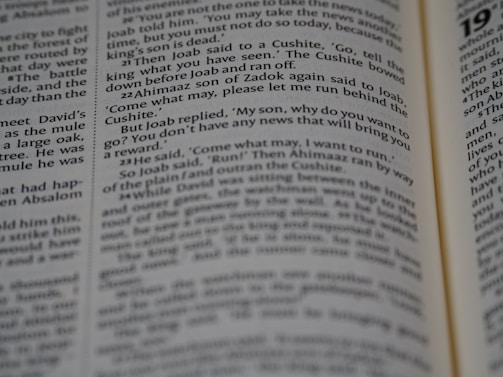 A close-up view of an opened book showing printed text in English. The focus is on the text in the central column, with surrounding text appearing slightly blurred due to the shallow depth of field.