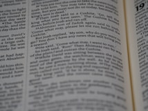 A close-up view of an opened book showing printed text in English. The focus is on the text in the central column, with surrounding text appearing slightly blurred due to the shallow depth of field.