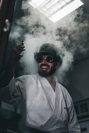 Man in white shirt with smoke, holding a vial—symbolizing discovery in male genetic screening