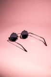 Stylish sunglasses resting on a bright, colorful surface with playful shadows