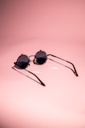 Stylish sunglasses resting on a bright, colorful surface with playful shadows