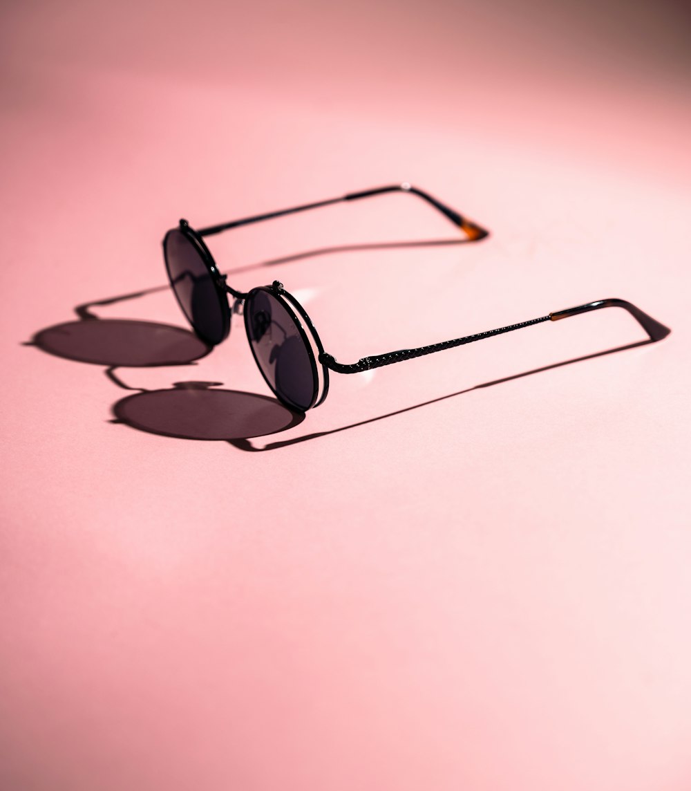 black framed sunglasses on white surface