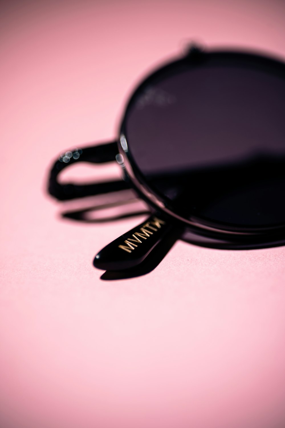 black framed sunglasses on pink surface