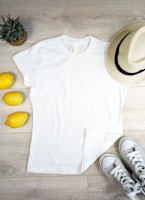 Flat lay of three tees in strong colors—blue, yellow, and white—arranged neatly on a wooden surface.