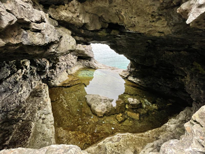 Famous Hercules Cave opening shaped like Africa, looking out to the sparkling sea beyond.