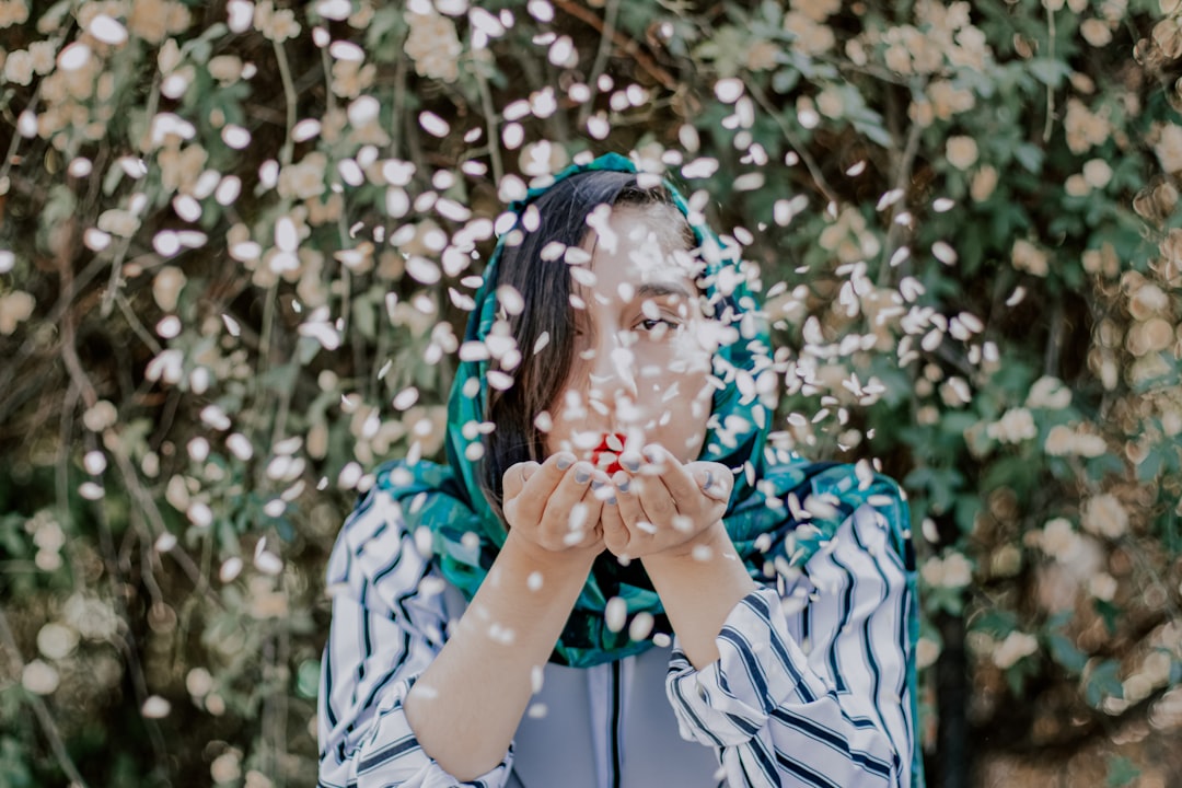 girl in white and blue long sleeve shirt blowing bubbles,
