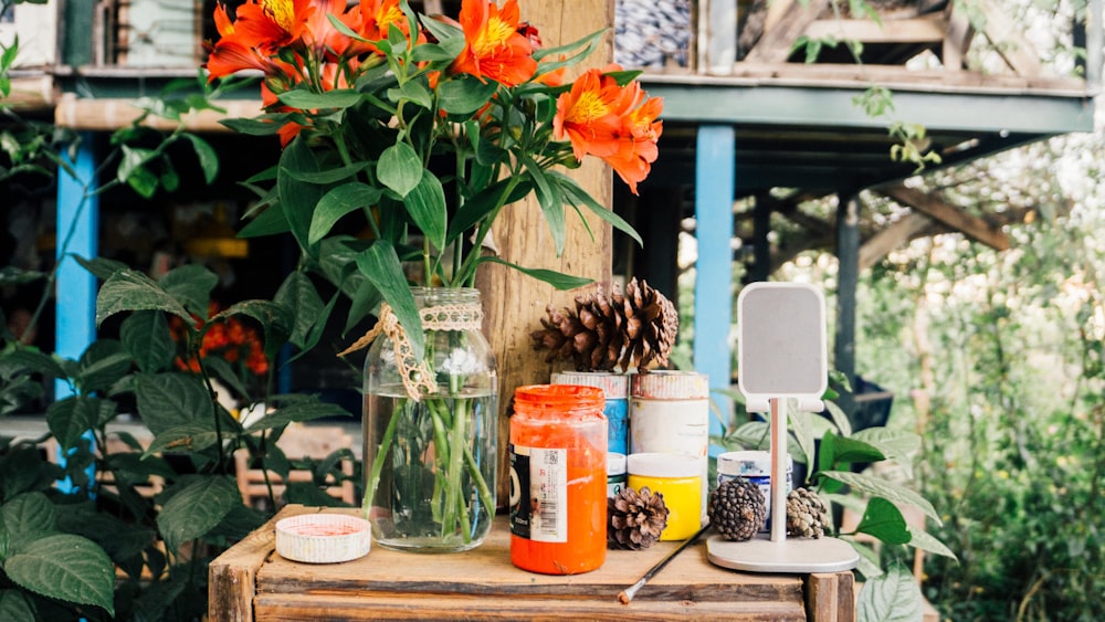 orange flower in clear glass jar