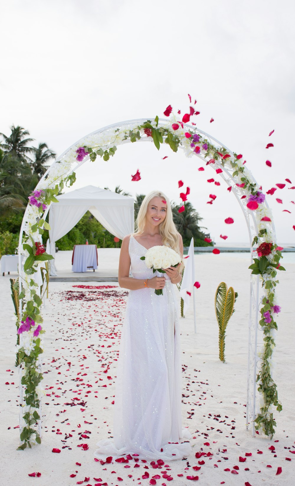 woman in white dress standing on white and pink floral textile