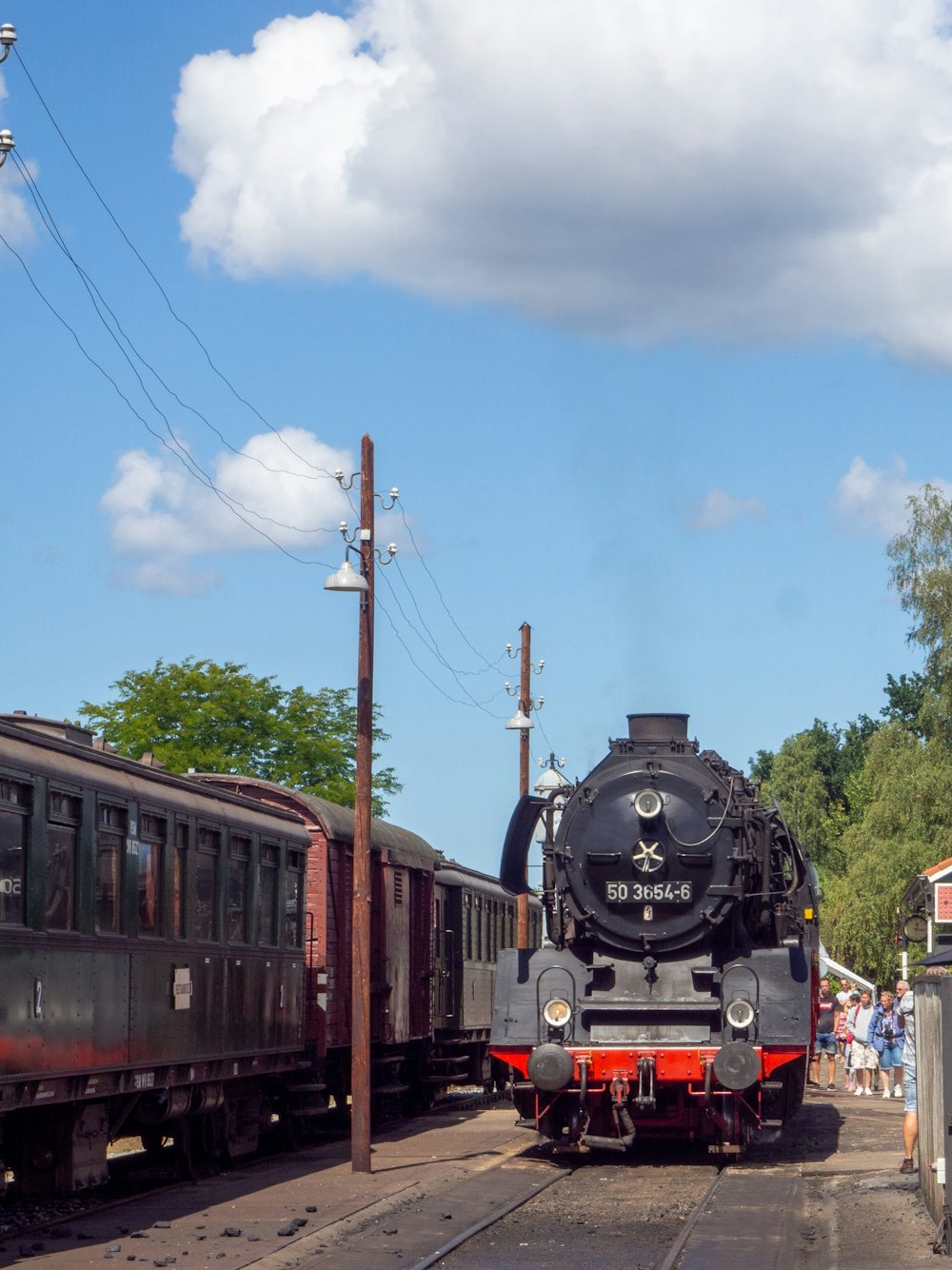 black train on rail under blue sky during daytime