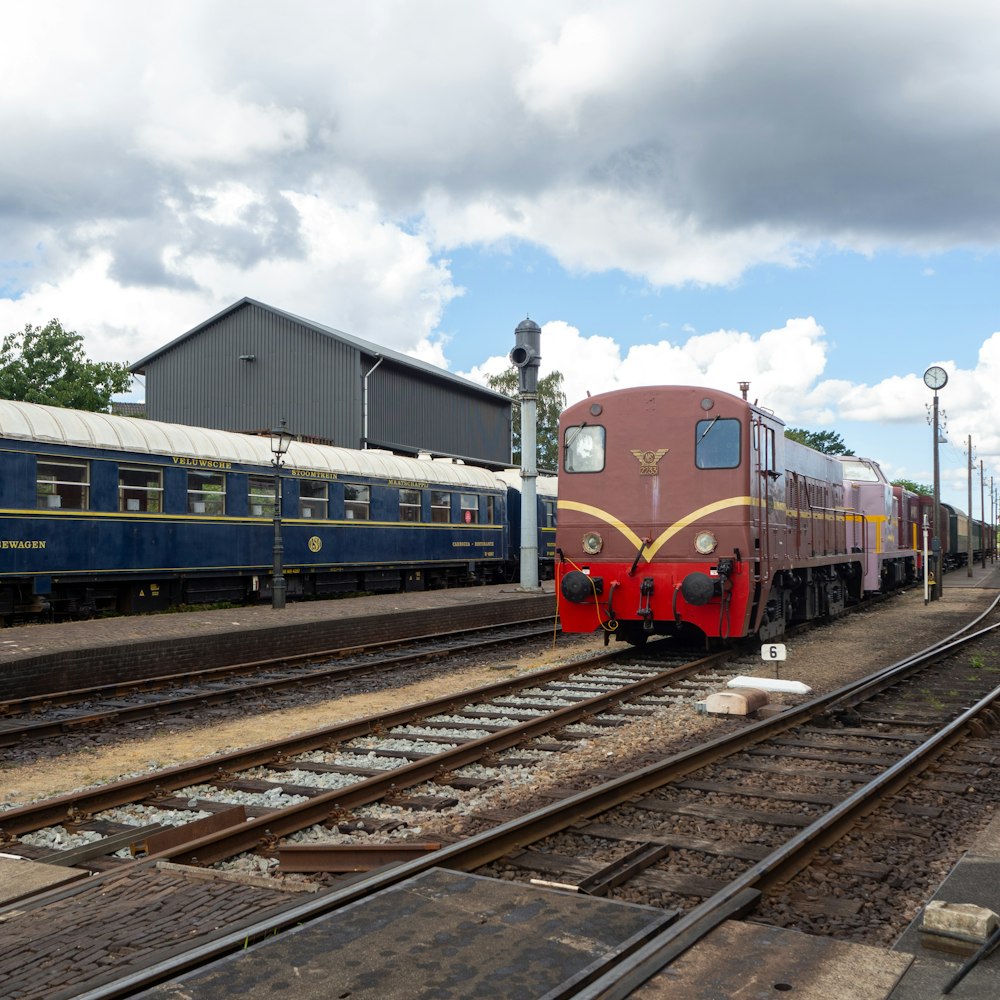 blue red and yellow train under cloudy sky during daytime