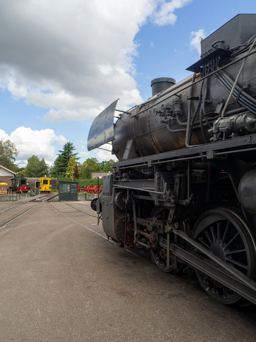 black and gray train under white clouds and blue sky during daytime