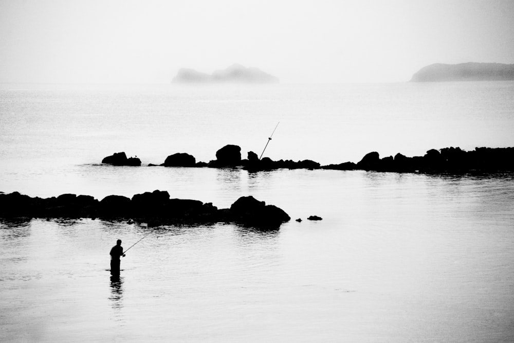 silhouette of 2 people on water during daytime