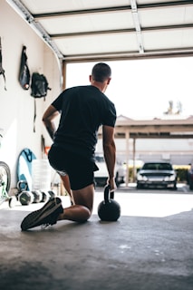 man in black t-shirt and black shorts standing on black and white basketball hoop