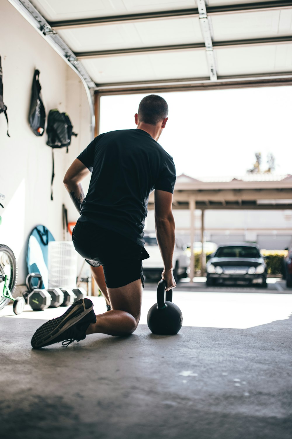 man in black t-shirt and black shorts standing on black and white basketball hoop