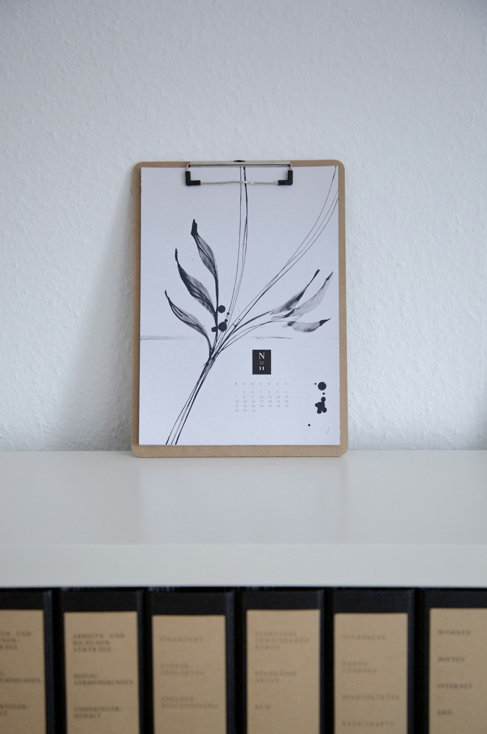 brown and white book on white wooden shelf