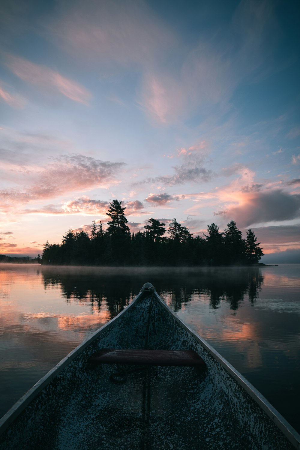 canoë brun sur le lac au coucher du soleil