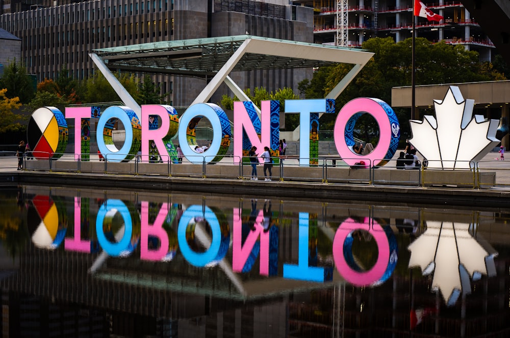the toronto sign is reflected in the water