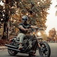 man in brown and green camouflage jacket riding black motorcycle